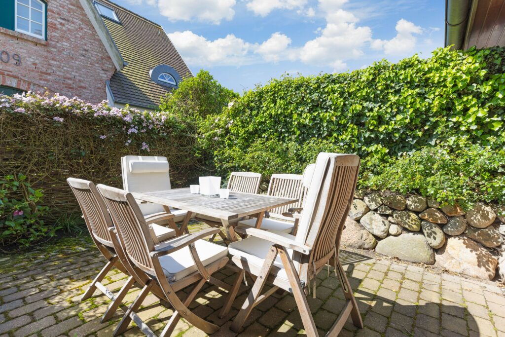 Holztisch und Stühle auf Terrasse an Ferienwohnung in Keitum