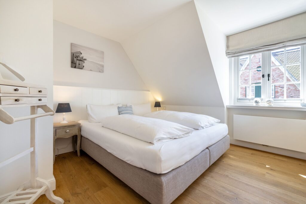 Doppelbett mit Strandfoto in Ferienwohnung in Keitum