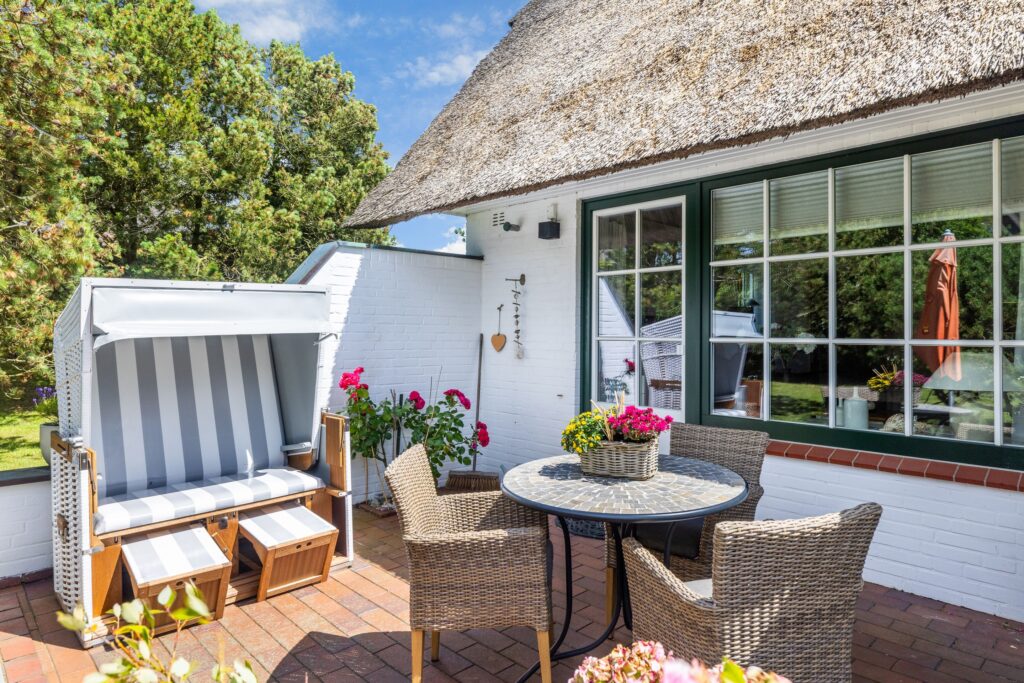 Strandkorb und kleiner Tisch mit Stühlen in Ferienwohnung auf Sylt