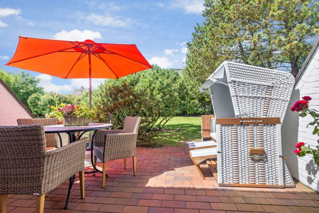 Terrasse mit Strandkorb und Sonnenschirm an Ferienwohnung auf Sylt