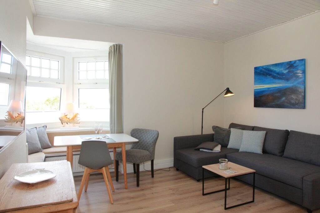 Wohnzimmer mit Sofa und Essbereich in Ferienwohnung auf Sylt