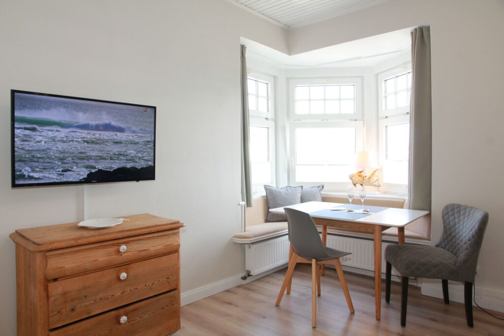 Wohnzimmer mit Essbereich und Fernsehen in Ferienwohnung auf Sylt