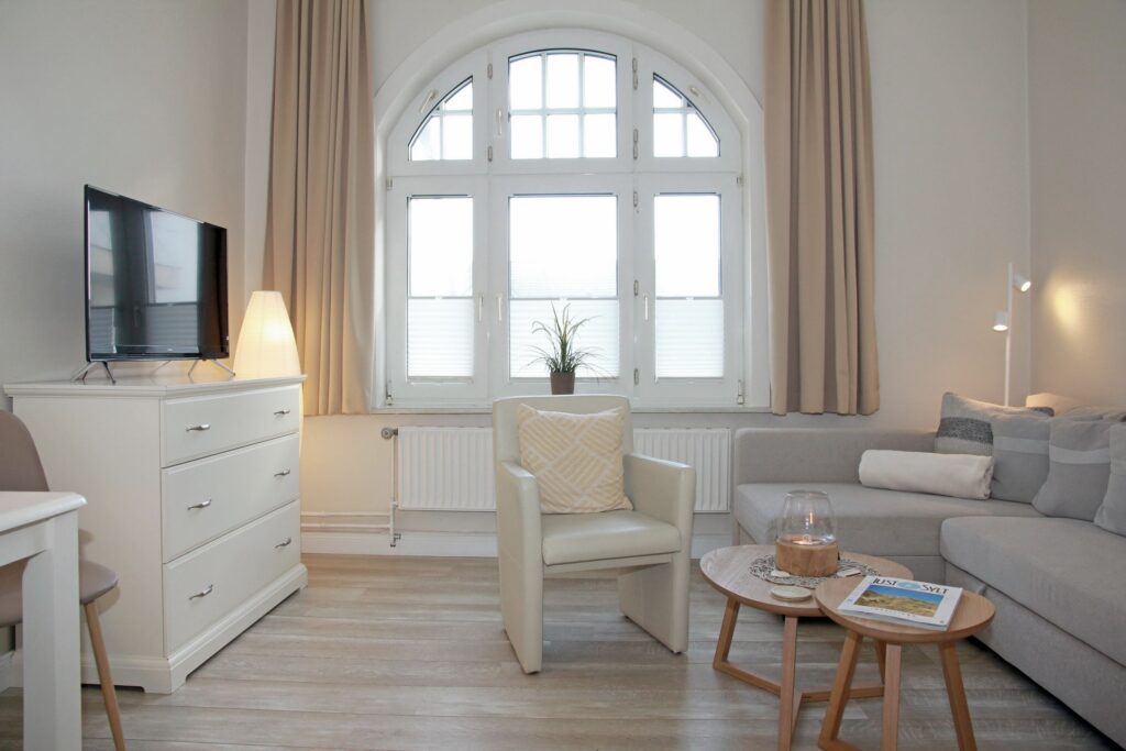 Wohnzimmer mit Sofa und Sessel in Ferienwohnung auf Sylt