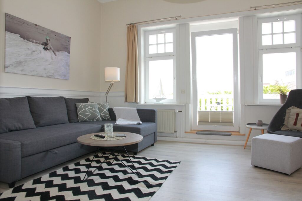 Sofa mit Kissen und Sessel in Ferienwohnung auf Sylt