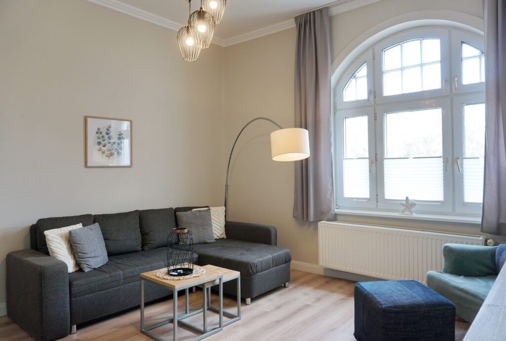 Wohnzimmer mit Sofa und Stehlampe in Ferienwohnung auf Sylt