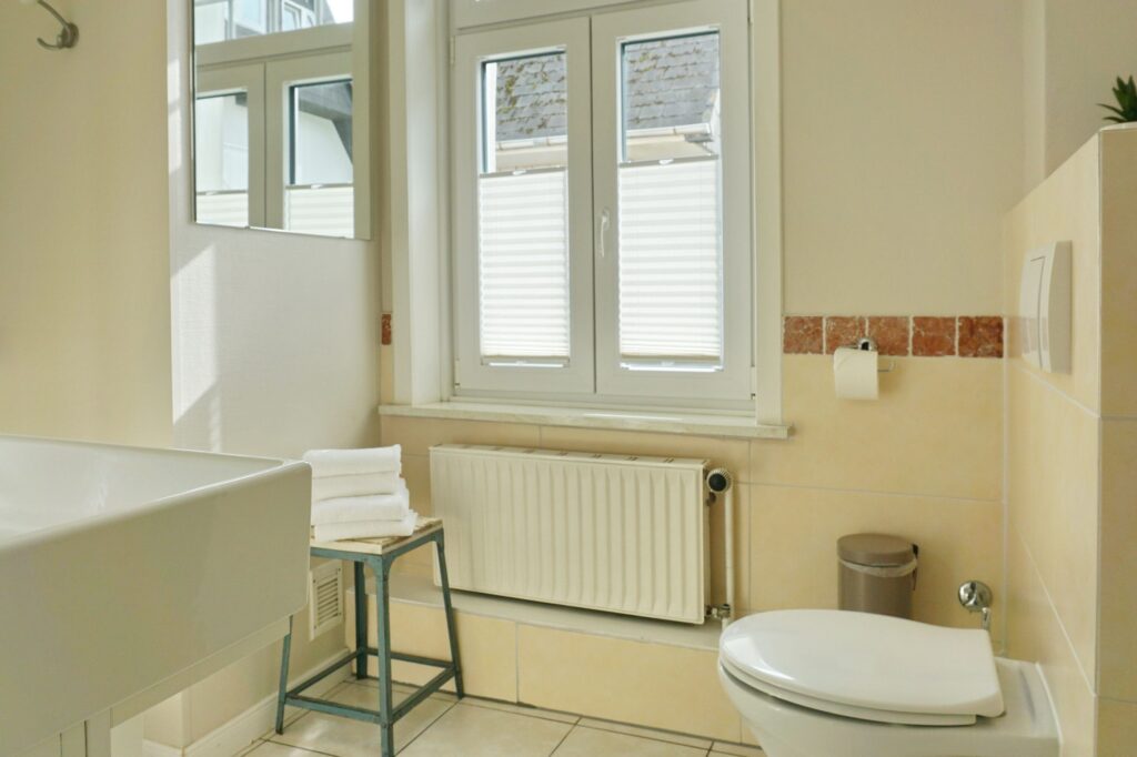 Badezimmer mit Toilette und Fenster in Ferienwohnung auf Sylt