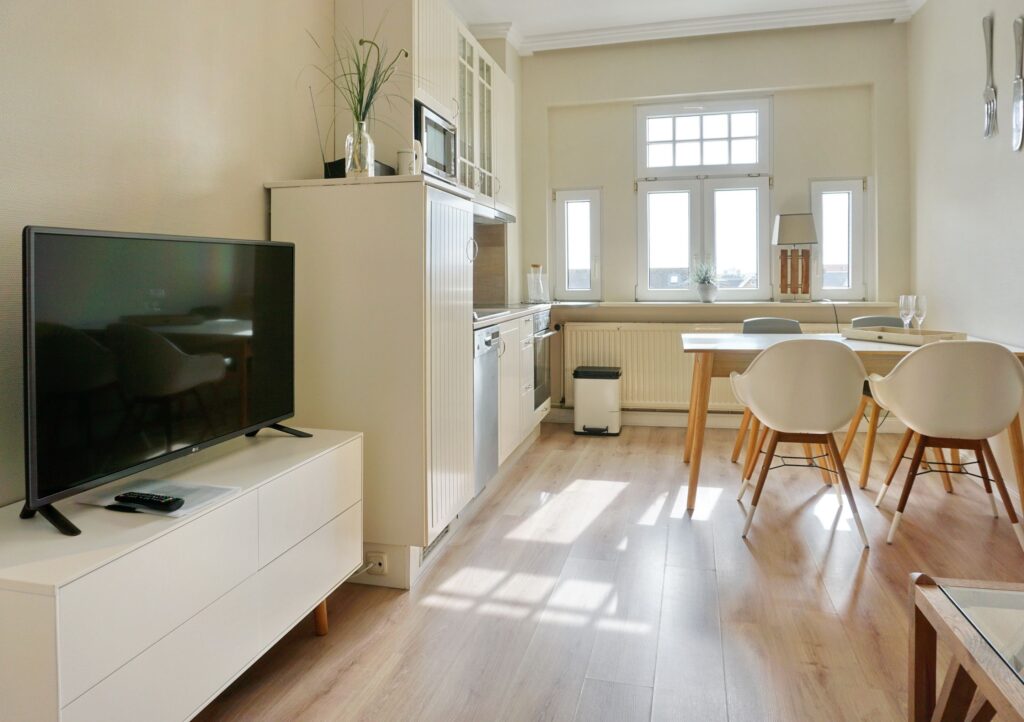 Küche mit Fernseher und Essbereich in Ferienwohnung auf Sylt