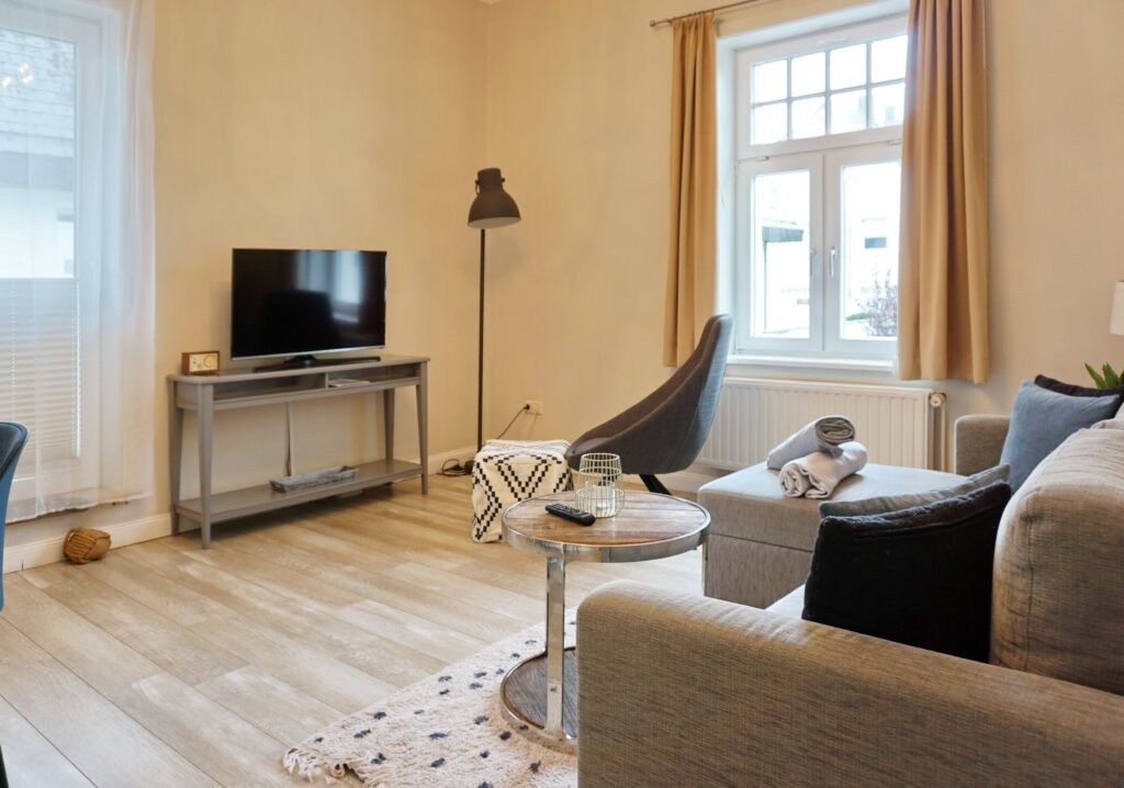 Wohnzimmer mit Sofa und Fernseher in Ferienwohnung auf Sylt