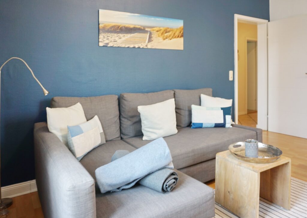 Sofa und blaue Wand in Ferienwohnung auf Sylt