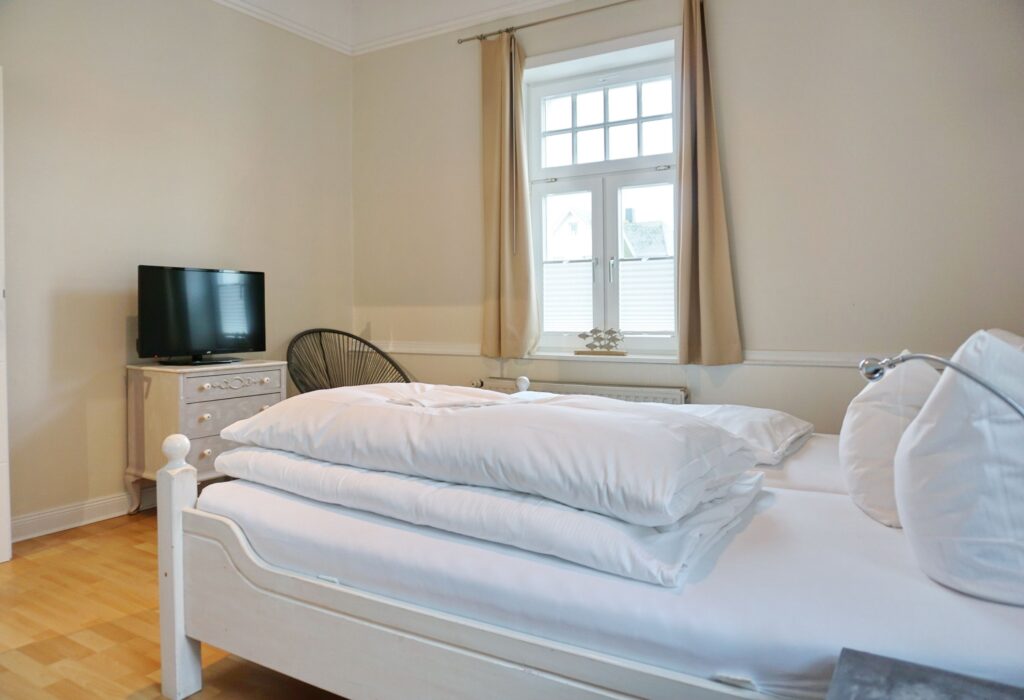 Doppelbett mit Fernseher in Ferienwohnung auf Sylt