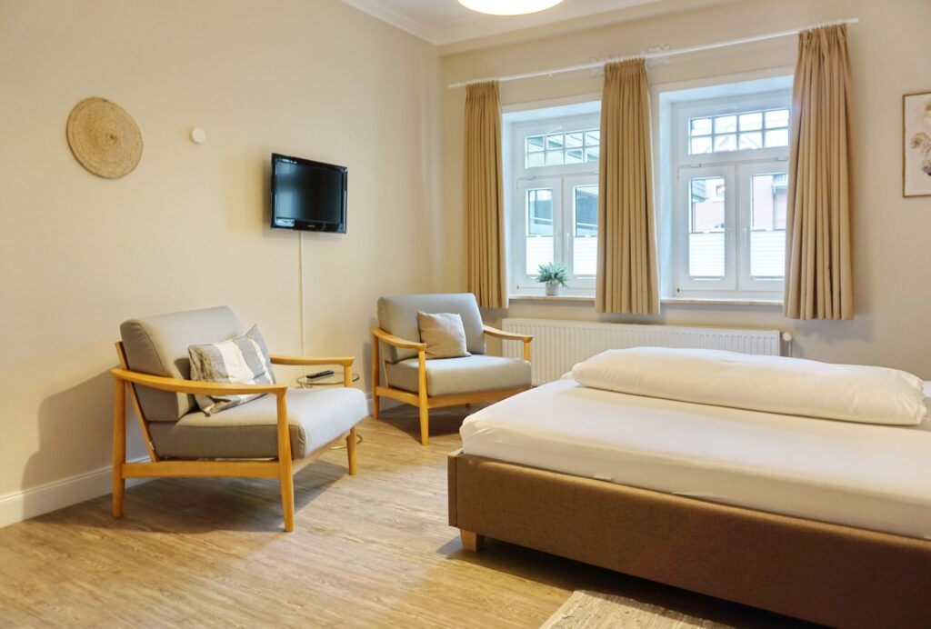 Doppelbett mit Fernseher im Schlafzimmer in Ferienwohnung auf Sylt