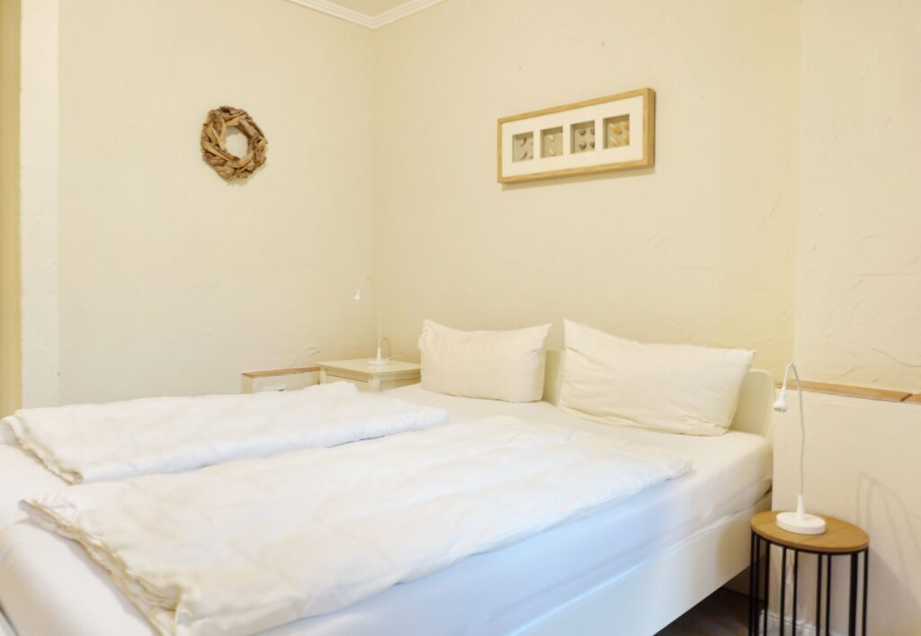 Doppelbett mit Nachttischlampen in Ferienwohnung auf Sylt