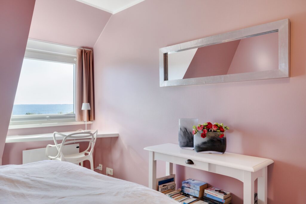 Schlafzimmer in rosa mit Spiegel in Ferienwohnung in Keitum auf Sylt